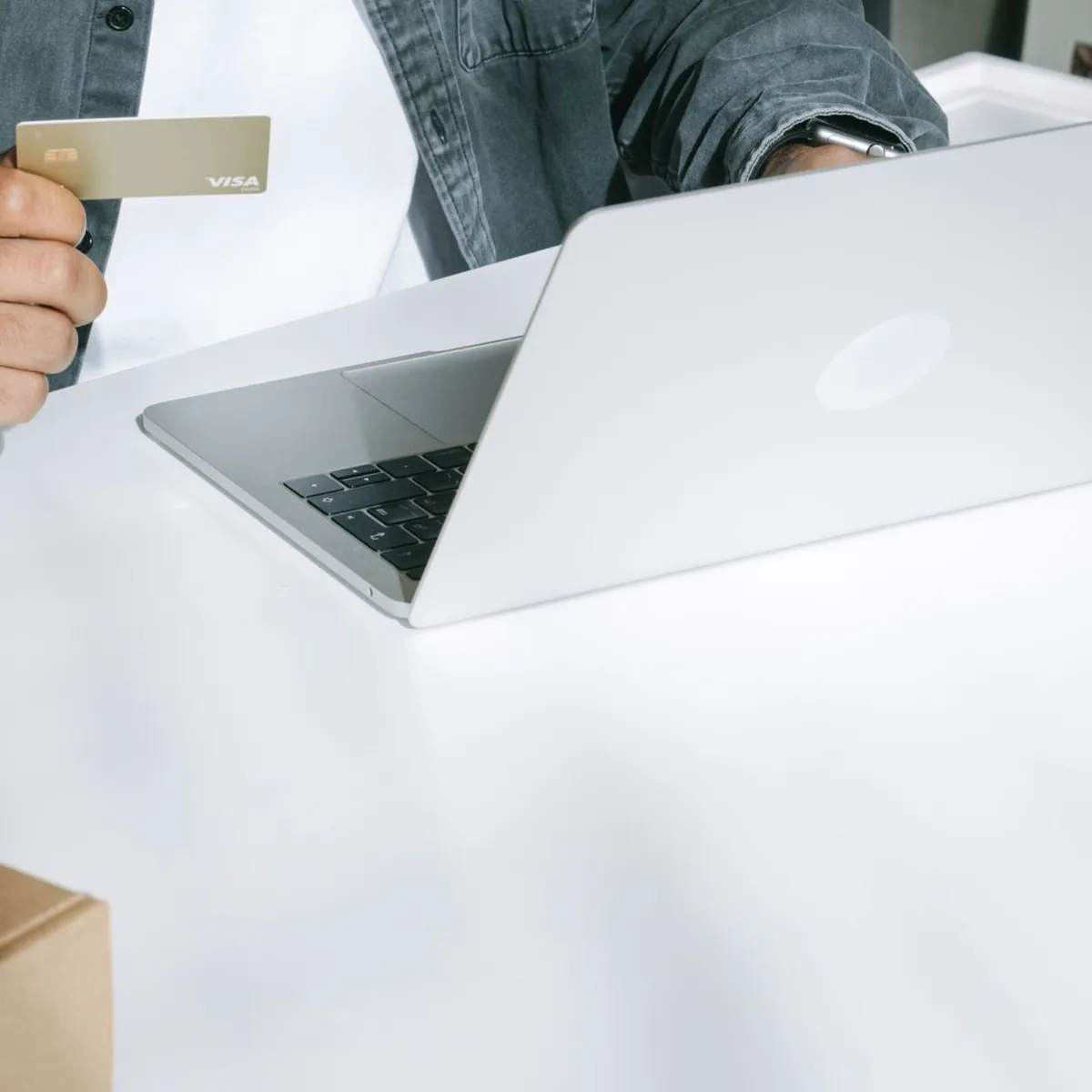 Una persona effettua un acquisto online accanto ad alcuni pacchi